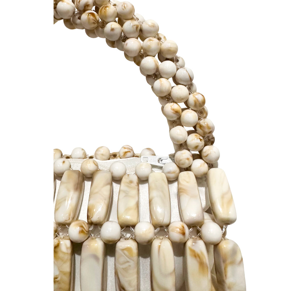 Close-up of a beaded bag with white and beige beads on a white background