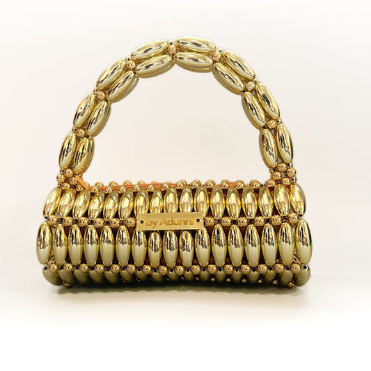 Gold handbag with decorative handle on a white background