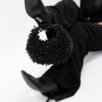 Black high-heeled shoes with decorative black circular design on a white background