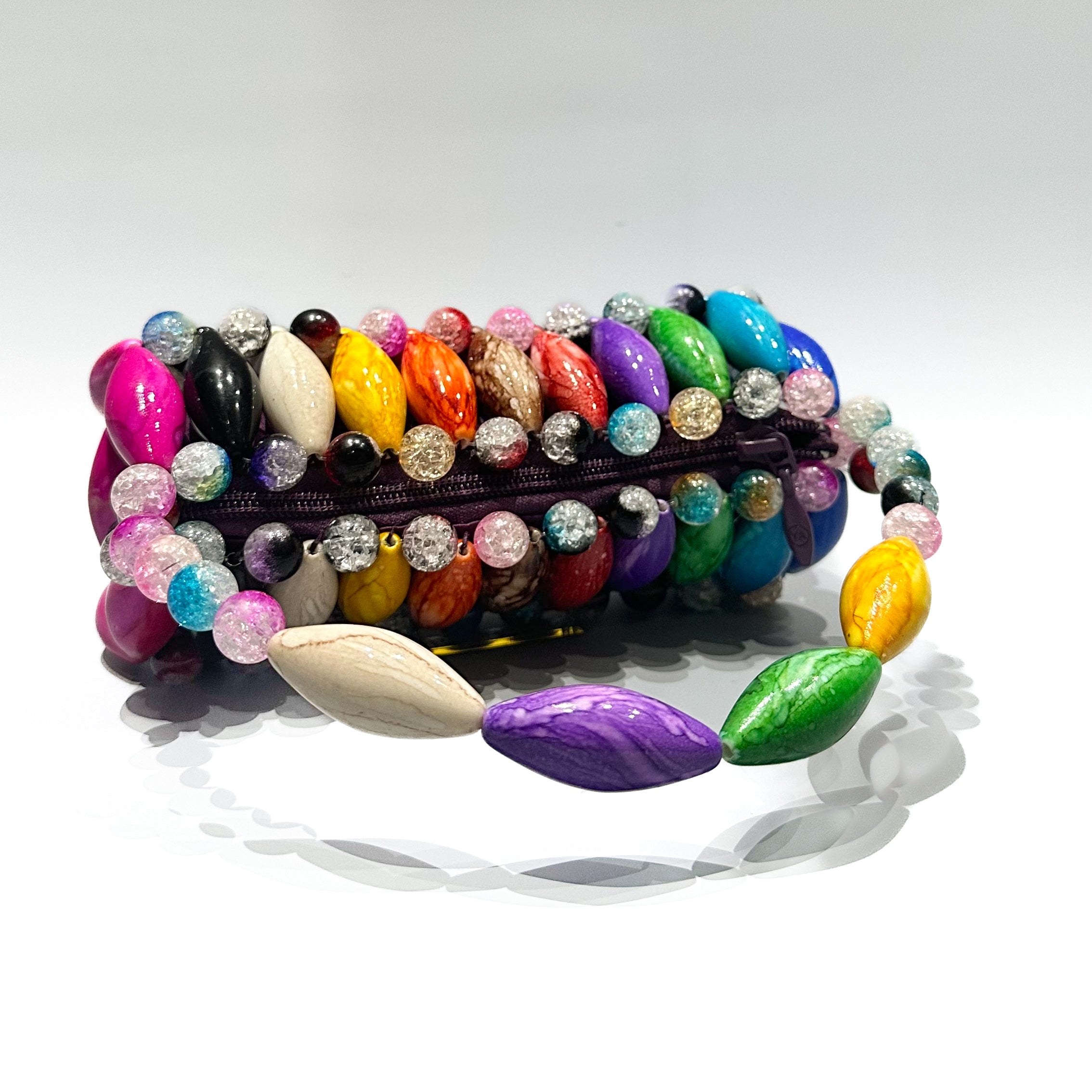 Colorful beaded bag laying on a white background
