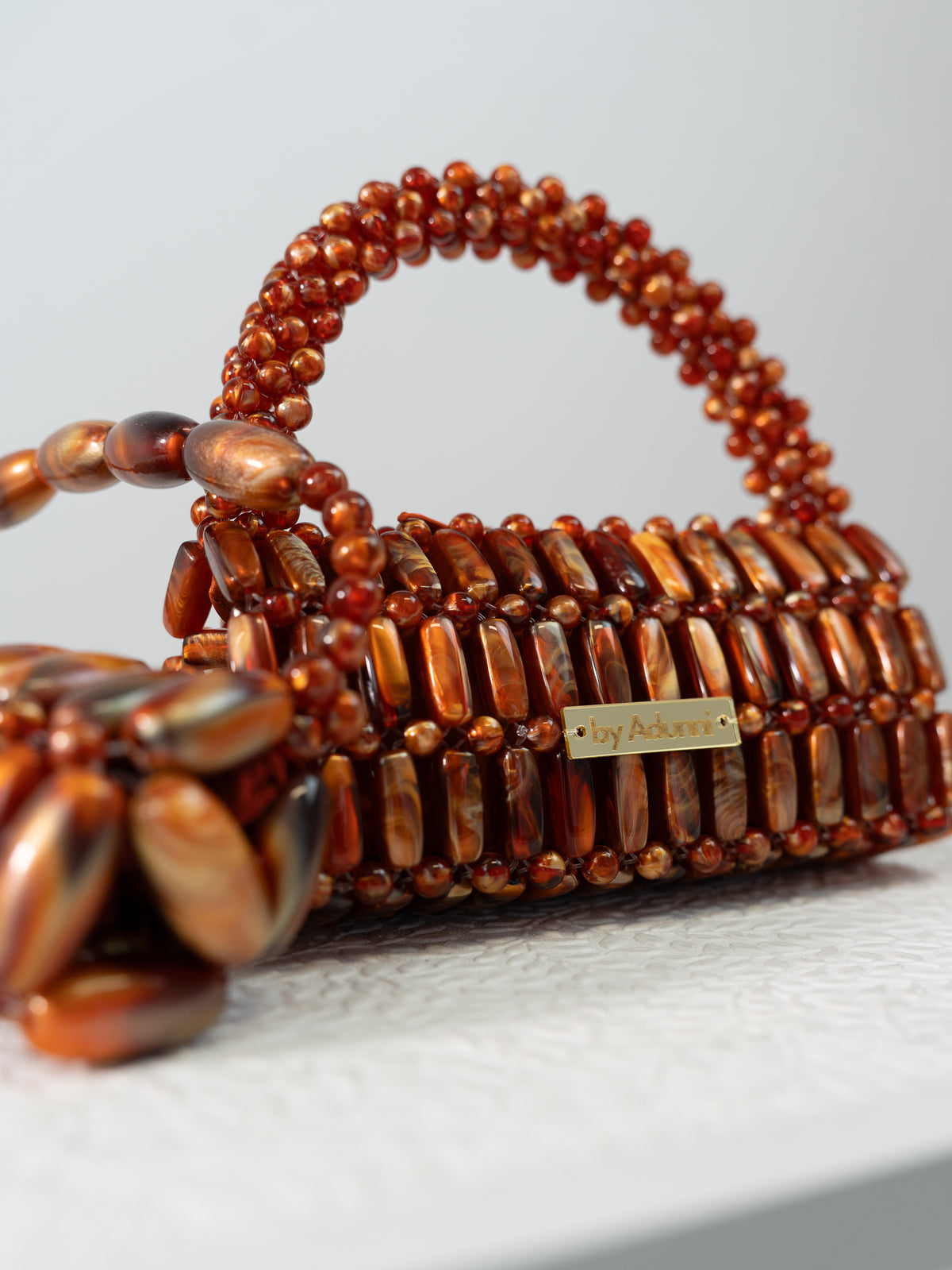 Close up of the Madagascar XL handmade beaded bag in glossy amber and brown tortoiseshell beads