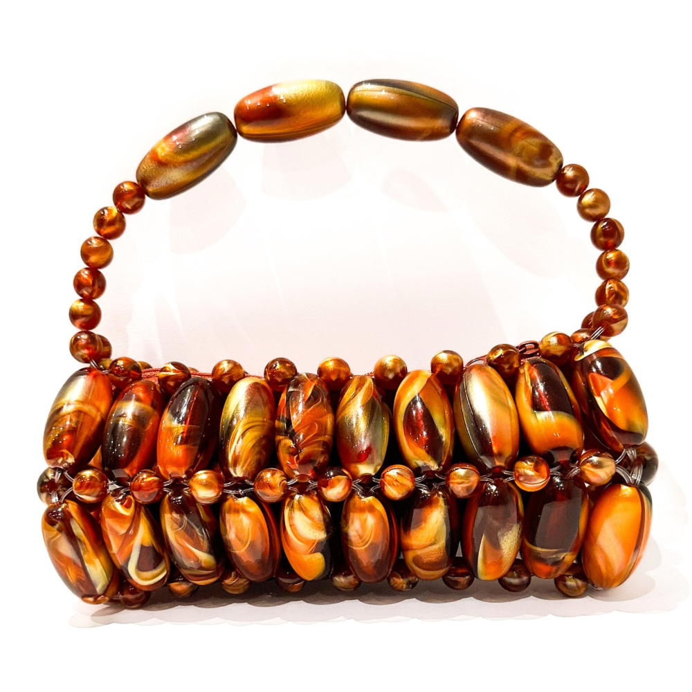 Close up of handmade beaded bag in madagascar - orange and brown tones