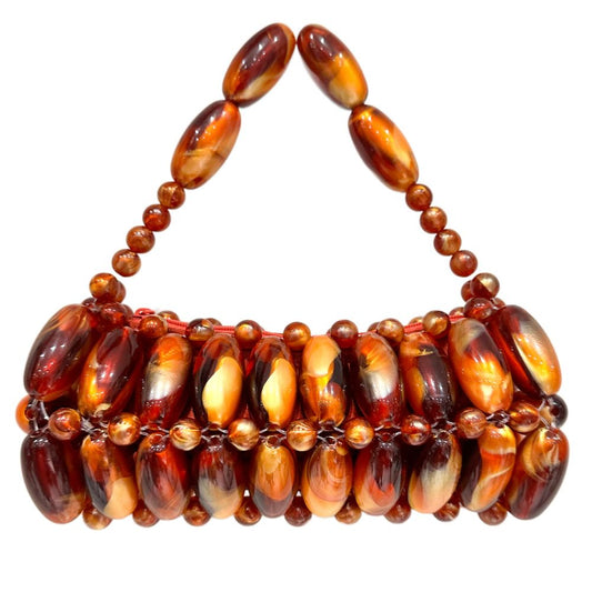 A handcrafted handbag made with multicolored beads, featuring an ombre effect with darker and lighter shades.