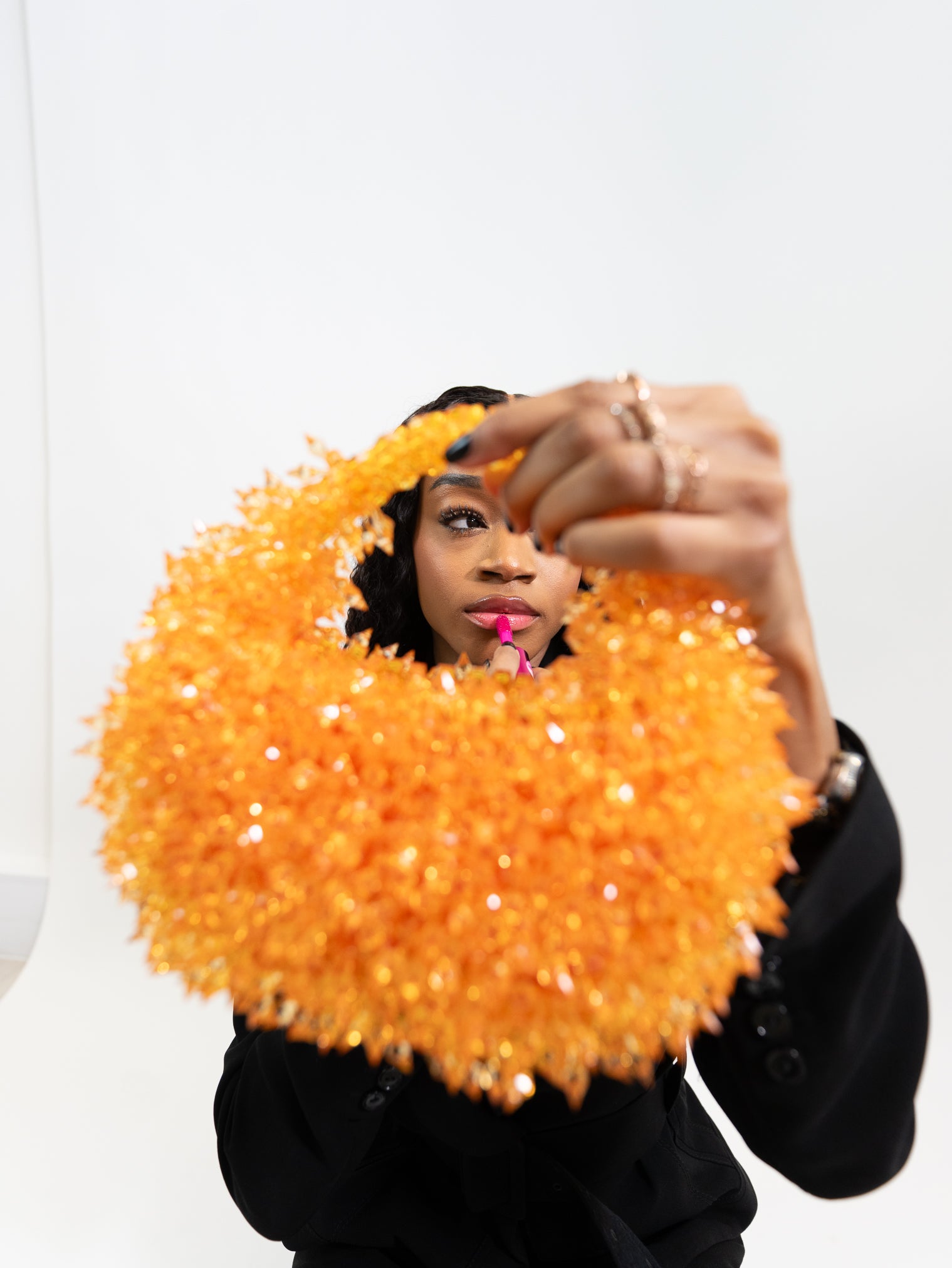 Person holding a large orange textured object against a white background
