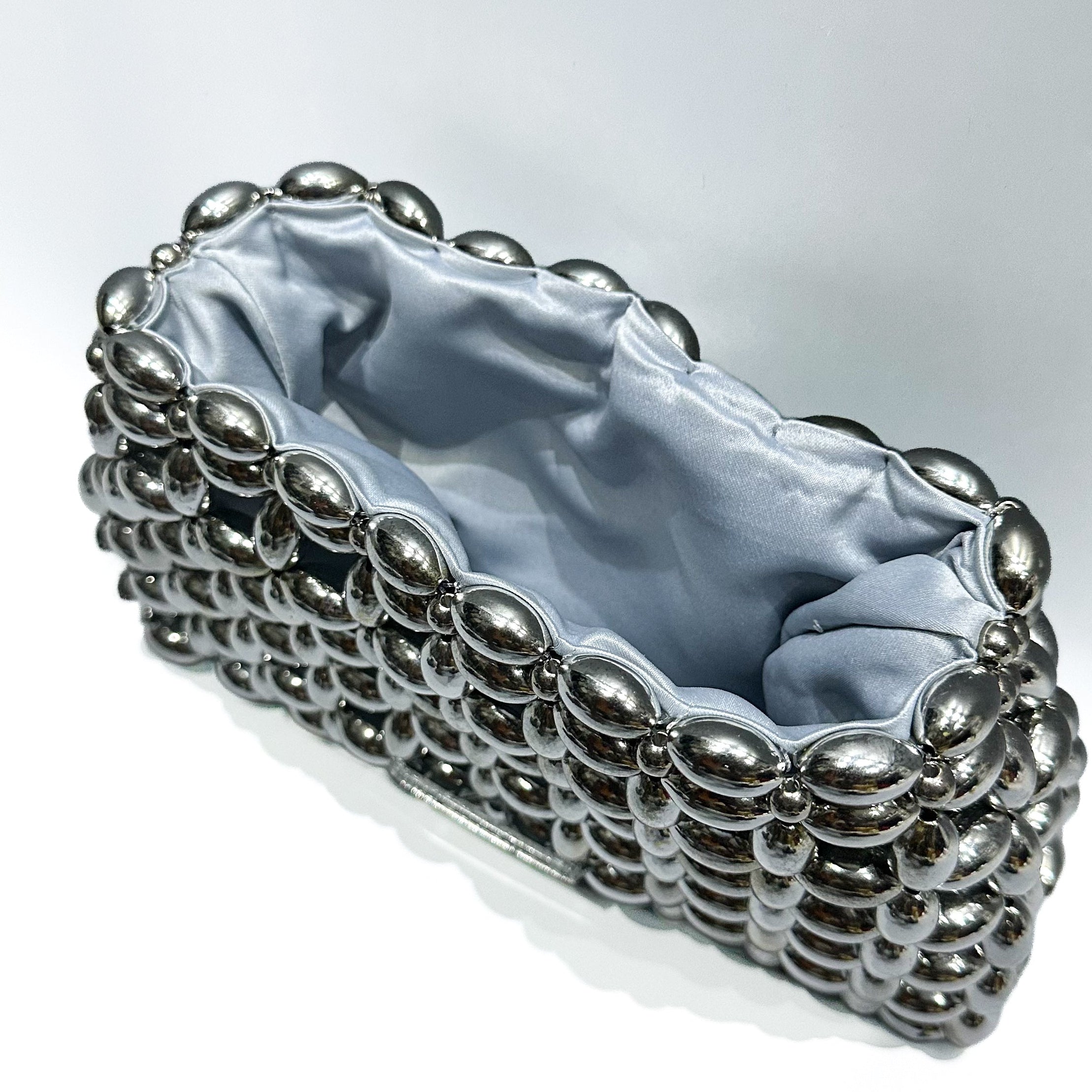 Silver beaded clutch bag on a white background