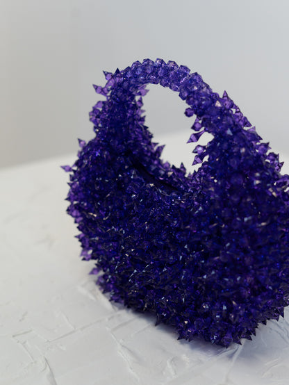 Purple crystal cluster on a textured white surface