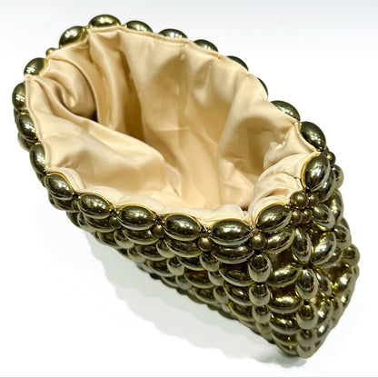 Gold studded clutch with beige interior on a white background