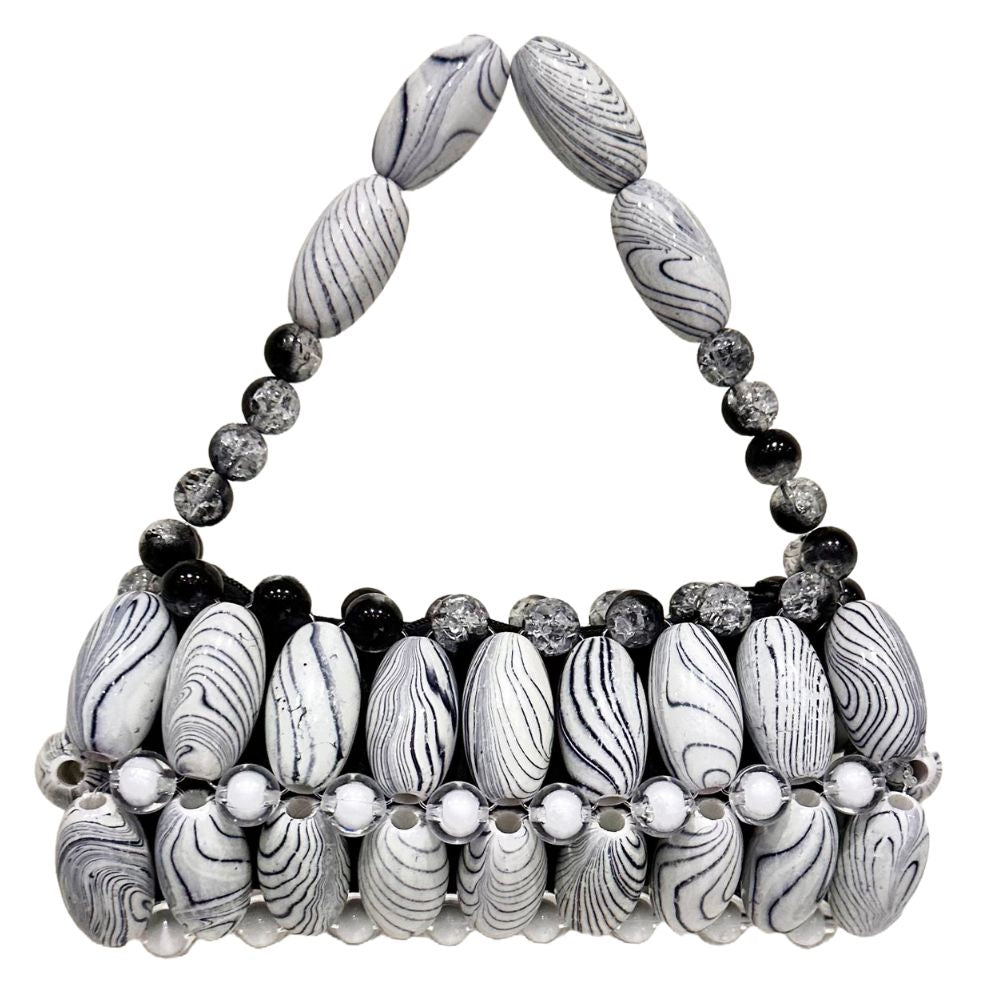 A handcrafted handbag featuring white zebra print beads with black accents and decorative elements.