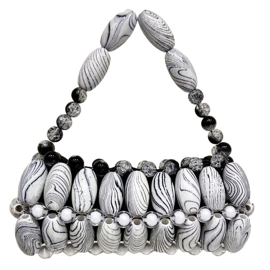 A handcrafted handbag featuring white zebra print beads with black accents and decorative elements.