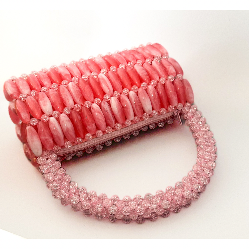 Pink beaded handbag on a white background