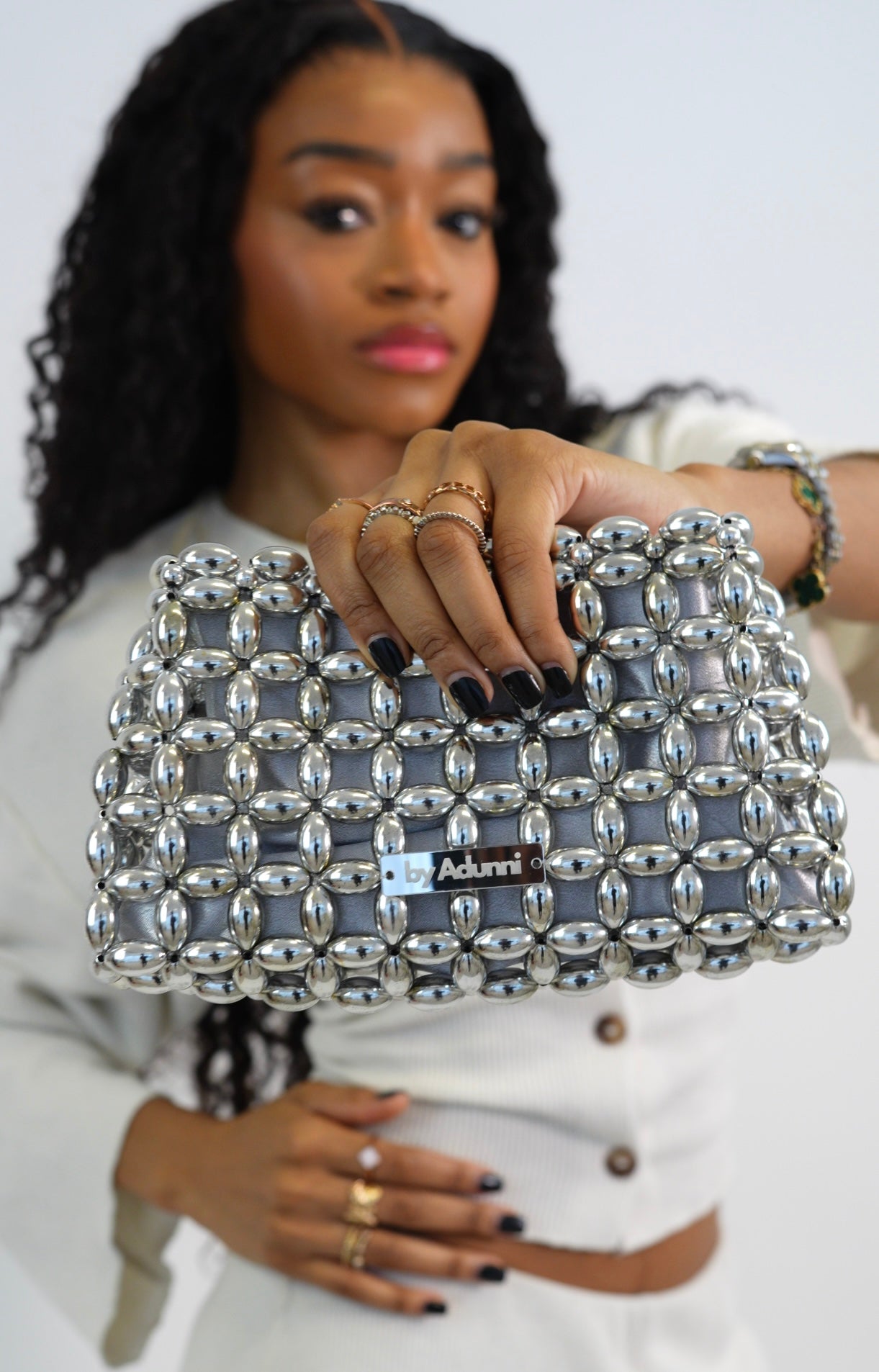 Woman holding a silver beaded clutch 