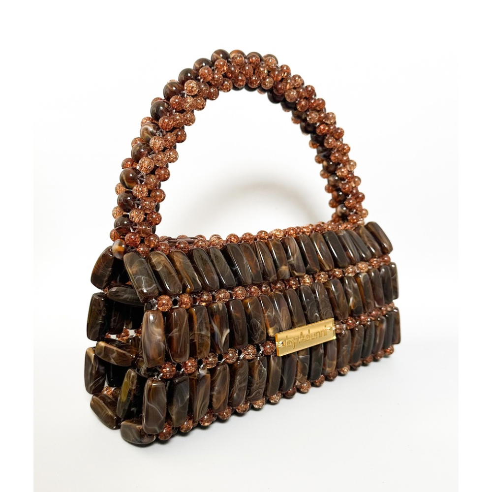 Brown beaded handbag with a handle on a white background