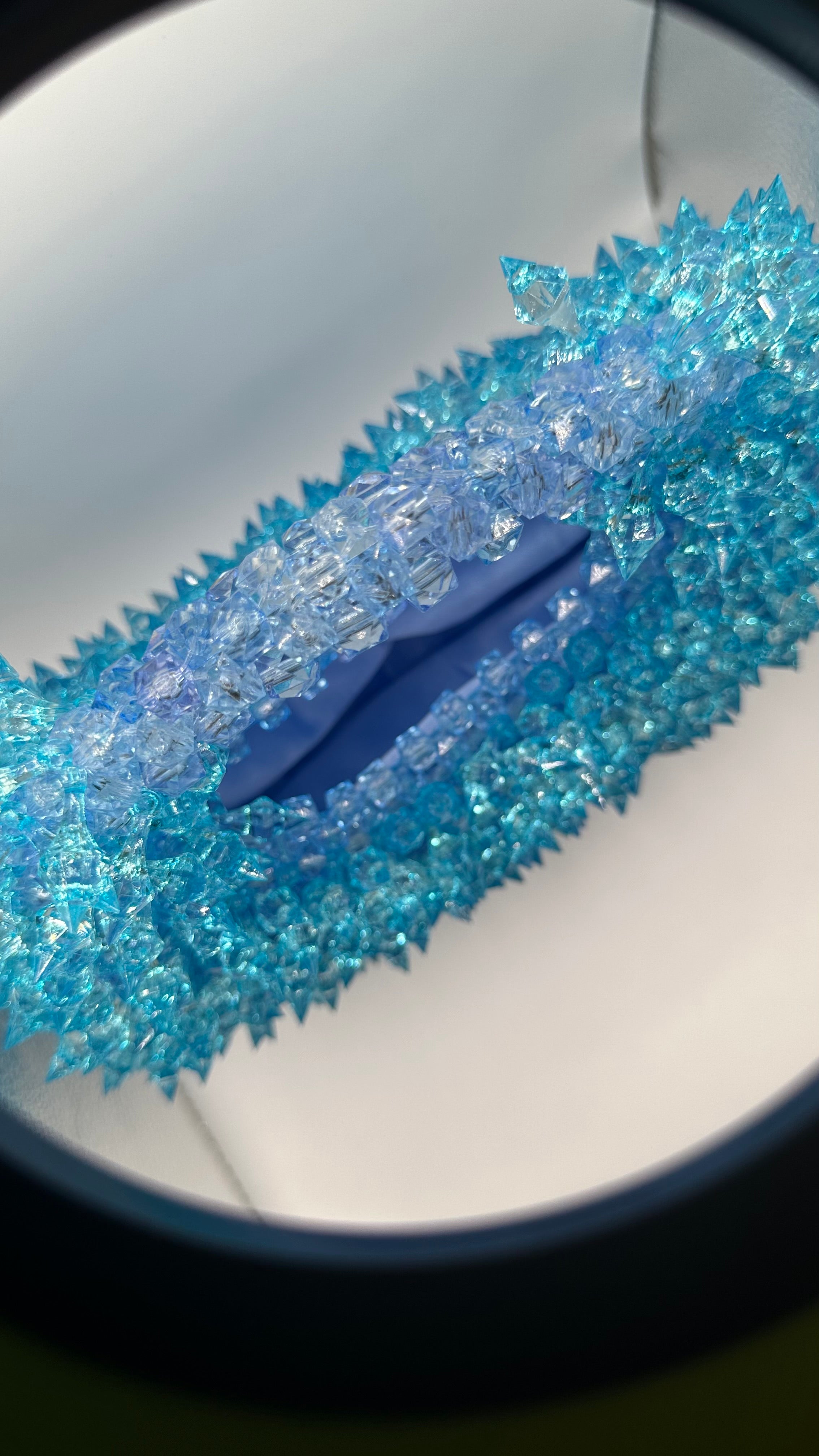 A close-up of a spiky blue beaded bag with satin lined interior in baby blue.